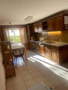 FlumsCasa Margerita的厨房配有木制橱柜、桌子和窗户。