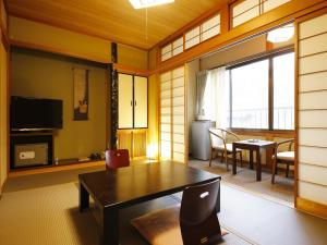 高山游传统日式旅馆的一间带桌子的客厅和一间餐厅