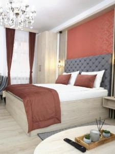 萨拉热窝Apartments Artee Free Garage Parking的一间卧室配有一张大床和一个吊灯。