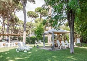 格罗塞托港La Meria di Maria La Terrazza的庭院内带白色椅子和桌子的凉亭