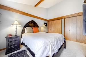 提顿村Golf Creek12的一间卧室设有一张大床和木墙