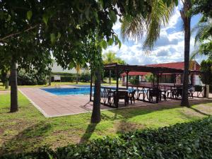 阿瓜斯卡连特斯HOTEL SAN MARCOS的一个带桌子的野餐区和一个泳池旁的凉亭