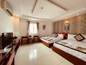 胡志明市SaiGon Europe Hotel的酒店客房设有两张床和电视。