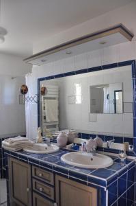 索尔格河畔利勒Villa avec piscine chez Raphaële的一间带两个盥洗盆和大镜子的浴室