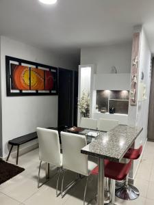 佩雷拉APARTAMENTO CONDINA PEREIRA的用餐室以及带桌椅的起居室。