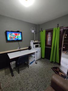 弗赖本托斯Suculento Apart的客厅配有书桌和绿色窗帘
