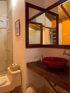 曼克拉La Casa de Pitty的一间带红色水槽和镜子的浴室
