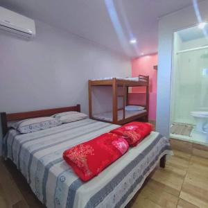 阿拉亚尔-杜卡布Space Hostel , quartos privativos的一间卧室配有一张红色枕头的床