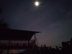 Cuatro EsquinasHostal Bullshark的一群人晚上站在月球下