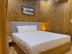 宁平Tam Coc Viet Ha Homestay的卧室配有白色的床和木墙