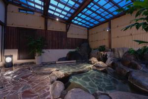 河津町Isoaruki no Yuyado Ushiogumo -6 years or older-的岩石和天花板的房间的水池
