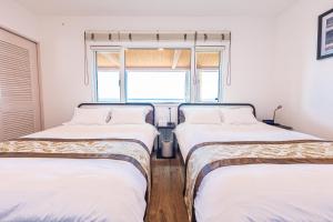 淡路Sunset Villa Awaji的带窗户的客房内设有两张单人床。