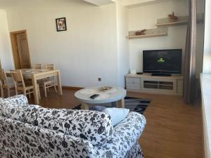 乌兰巴托Lovely 2 BR unit with city view的带沙发、电视和桌子的客厅