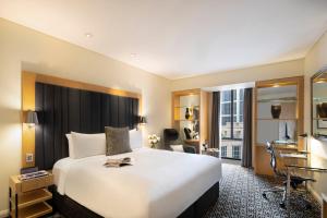 悉尼索菲特悉尼温特沃什酒店的酒店客房设有一张大床和一张书桌。