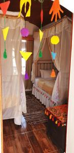 阿斯旺Old Nubian guest house的一间卧室配有一张带彩色纸风筝的天蓬床