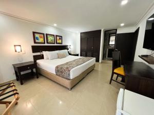 圣玛尔塔Hotel Arhuaco Rodadero的一间卧室配有一张大床、一张书桌和一张四柱床。