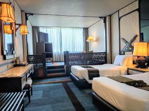 清迈Chiang Mai Orchid Hotel SHA EXTRA PLUS的酒店客房设有两张床和电视。