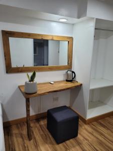 那牙Borj Place的配有一张桌子、镜子和凳子的房间