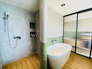 南湾厝True Hub旅店的一间带浴缸和淋浴的浴室