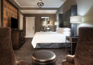 新奥尔良Le Pavillon New Orleans的酒店客房,配有一张床和两把椅子