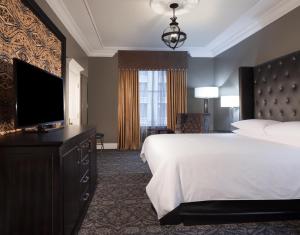 新奥尔良Le Pavillon New Orleans的配有一张床和一台平面电视的酒店客房