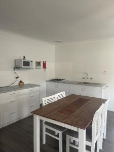 巴瑟尔顿巴瑟尔顿码头公寓的厨房配有木桌和白色橱柜。