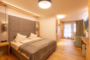 皮茨河谷圣莱昂哈德Hotel Mittagskogel Pitztal的一间卧室设有一张大床和一个窗户。