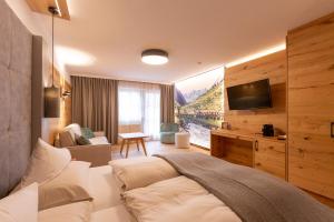 皮茨河谷圣莱昂哈德Hotel Mittagskogel Pitztal的一间卧室配有一张床和一台电视。
