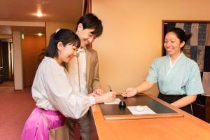 静冈羽衣日式旅馆的三人站在桌子旁