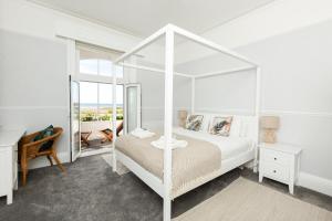 滨海韦斯特盖特SoHot Stays - Sea Views From Every Room的白色卧室设有天蓬床和镜子