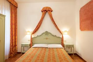 威尼斯Hotel al Sotoportego的一间卧室配有一张带两张桌子的绿色床