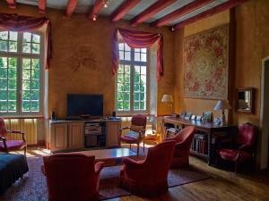 Labastide-du-Vert拉穆林酒店的客厅配有电视、书桌和椅子