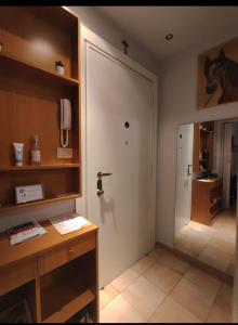 米兰Appartamento Diego的一间设有门的房间和一张带电话的桌子