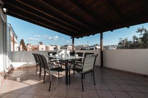 雅典Blue Riviera villas & suites - Alimos 2的屋顶上带桌椅的天井