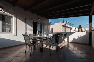 雅典Blue Riviera villas & suites - Alimos 2的阳台的天井配有桌椅