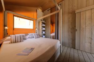 科马鲁加万德雷利普拉佳露营地的一间卧室设有一张大床和一个窗户。