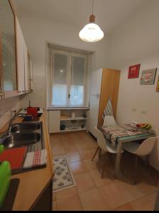 米兰Appartamento Diego的厨房配有桌子、水槽和桌椅
