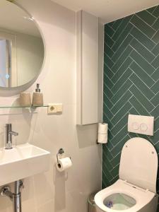 鹿特丹B&B Berglust的一间带卫生间、水槽和镜子的浴室