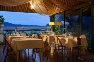 圣费利切德尔贝纳科索尼欧餐厅酒店的一间设有白色桌椅的餐厅,享有美景
