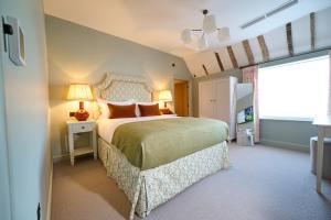 斯托克拜奈兰德The Angel Inn, Stoke-by-Nayland的一间卧室设有一张大床和一个窗户。