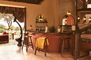 安博塞利塔威山林小屋的一间酒吧,房间设有凳子和桌子