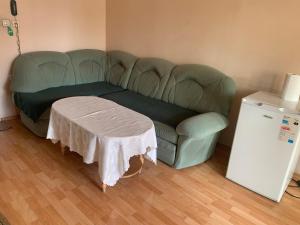 Vratsa拉德2号酒店的一张绿色沙发,一张桌子放在房间里