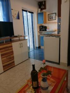 普利拉卡Apartments Topić的厨房配有1瓶餐桌上的葡萄酒
