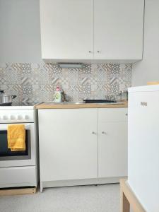 库尔迪加Pigeon apartment的厨房配有白色橱柜和炉灶。