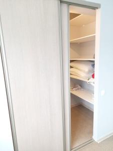 库尔迪加Pigeon apartment的白色衣柜,带玻璃门和衣柜