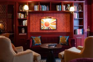 伦敦Sun Street Hotel Shoreditch的一间带椅子、桌子和书架的房间