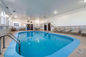 罗密欧维尔Comfort Inn Romeoville - Bolingbrook的一个带椅子的房间的大型游泳池