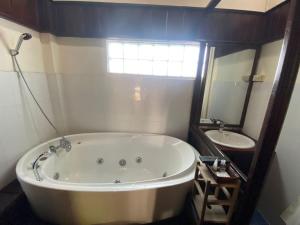 琅勃拉邦旺萨维饭店的一间带大浴缸和水槽的浴室