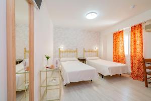 安特克拉Hotel Manzanito的一间医院间,配有两张床和镜子