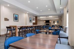 帕迪尤卡Comfort Suites的餐厅设有木桌和蓝色椅子
